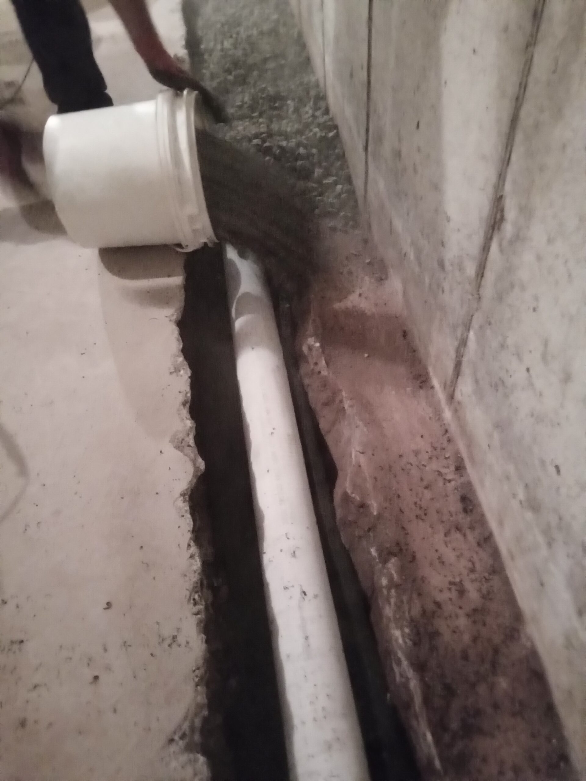 Filling in a drain trench as part of a basement waterproofing in Dingmans Ferry PA.