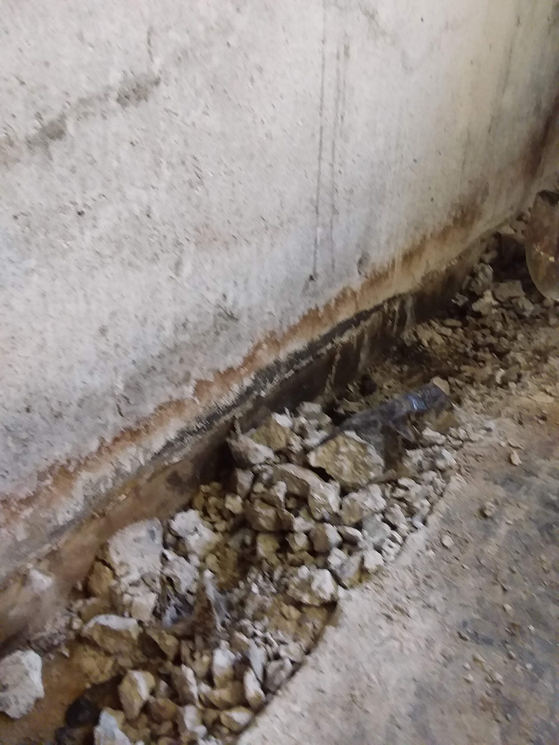 Digging drainage trench to get rid of water during a basement waterproofing in Washington Township NJ.